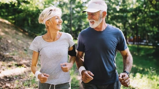 Ältere Frau und Mann beim Joggen durch den Wald