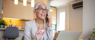 Frau arbeitet im Home-Office, telefoniert und schaut konzentriert auf den Laptop – schwindelfreise Arbeiten.