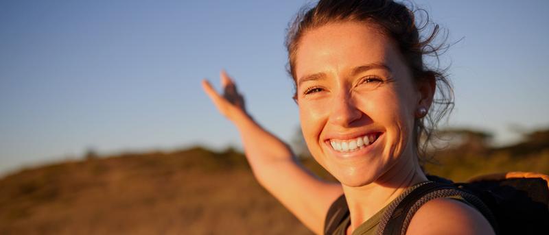 Fröhliche junge Frau genießt die Natur und frische Luft.