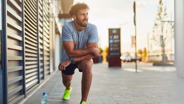 Mann macht Dehnübung nach dem Laufen – fördert Gelenkgesundheit und beugt Beschwerden vor.