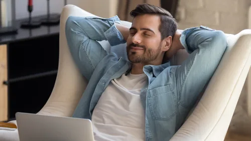 Mann sitzt in einem Stuhl und entspannt sich.