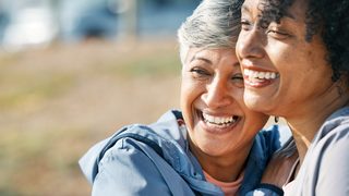 Frauen lachen und umarmen sich während der Periode.