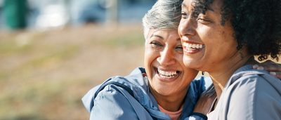 Frauen lachen und umarmen sich während der Periode.