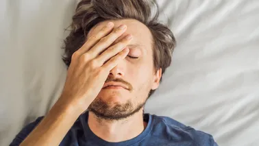 Mann liegt im Bett und kann nicht schlafen.