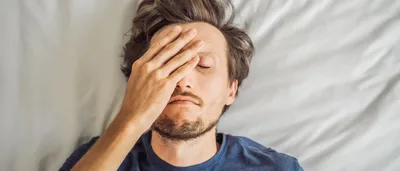 Mann liegt im Bett und kann nicht schlafen.