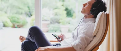 Mann hört über Kopfhörer entspannende Klaviermusik