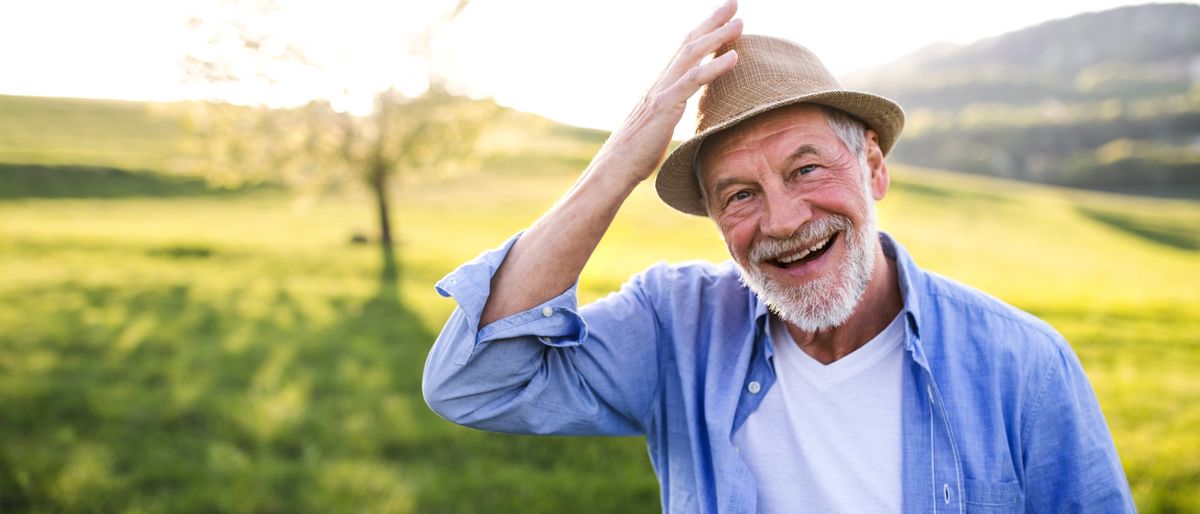 Älterer Mann mit Hut in der Natur.