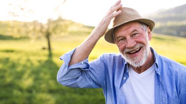 Älterer Mann mit Hut in der Natur.
