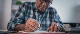 Mann schreibt in ein Schwindel-Tagebuch.