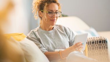 Frau sitzt auf dem Sofa und liest