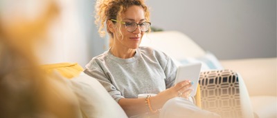 Frau sitzt auf dem Sofa und liest