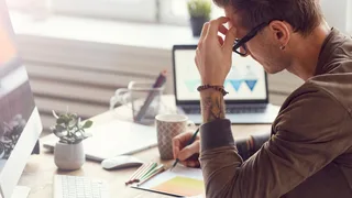 Mann sitzt an einem Schreibtisch und arbeitet.