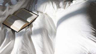 Offenes Buch liegt im Bett