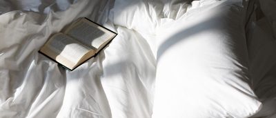 Offenes Buch liegt im Bett