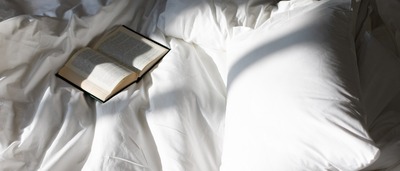 Offenes Buch liegt im Bett
