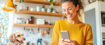 Soziale Medien & Stress: Frau in gelbem Pullover fokussiert sich auf ihr Smartphone