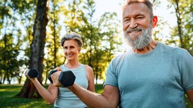 Älteres Paar trainiert mit Hanteln und achtet auf die richtige Atmung zur Unterstützung der Muskelkraft