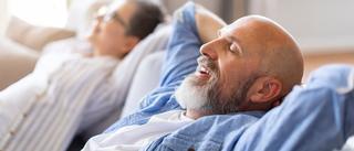Ältere Mann und Frau entspannen zuhause auf der Couch.