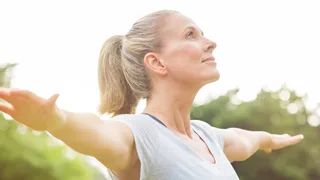 Frau macht in der Natur eine Sportübung.