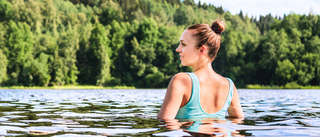 Frau entspannt sich beim Schwimmen im See um Stress abzubauen.