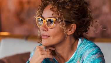 Frau mit Brille denkt nach.