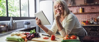Frau kocht gesundes Essen in einer Küche.