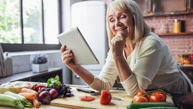 Frau kocht gesundes Essen in einer Küche.