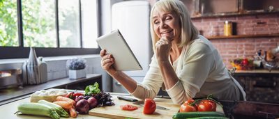 Frau kocht gesundes Essen in einer Küche.