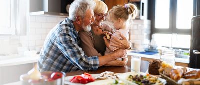 Älteres Paar mit Enkelkind in der Küche – gesunde Ernährung für die Funktion des Verdauungssystems
