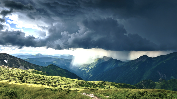 Sturmwolken über Gebirge mit Regen – symbolisiert wetterbedingte Einflüsse auf Gelenke.