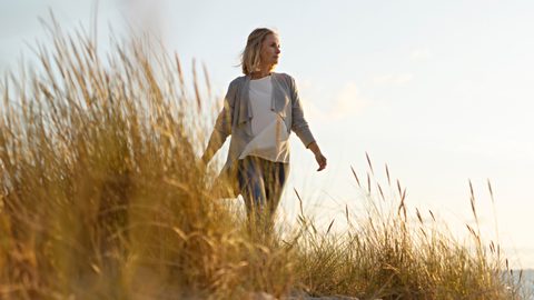 Frau geht am Strand spazieren