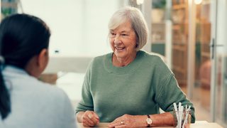 Ältere Frau im Gespräch mit einer Ärztin.