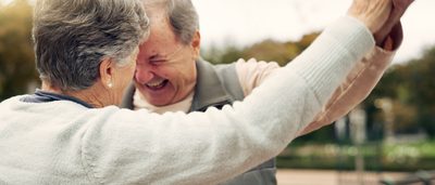 Älterer Mann und ältere Frau tanzen in der Natur.