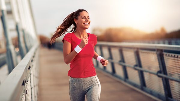 Junge Frau joggt auf einer Brücke was zu ihrer Persönlichkeit gut passt