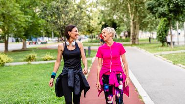 Zwei Frauen unterhalten sich beim Spazierengehen.