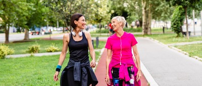 Zwei Frauen unterhalten sich beim Spazierengehen.