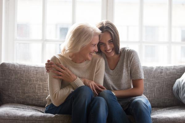 Zwei Frauen umarmen sich herzlich und lachen innig - fuer ein stressfreies Leben