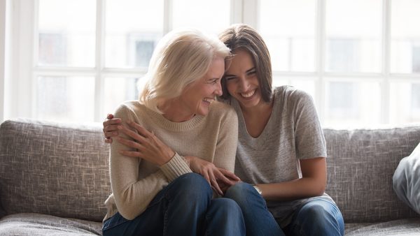 Zwei Frauen umarmen sich herzlich und lachen innig - fuer ein stressfreies Leben