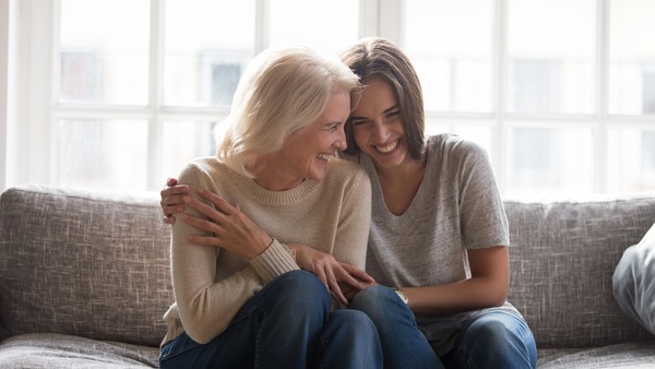 Zwei Frauen umarmen sich herzlich und lachen innig - fuer ein stressfreies Leben