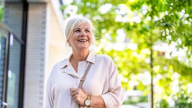 Ältere Frau bei Spaziergang durch Stadt.