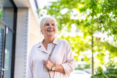 Ältere Frau bei Spaziergang durch Stadt.