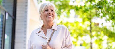 Ältere Frau bei Spaziergang durch Stadt.