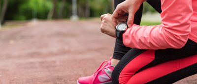 Frau checkt ihre Herzfrequenz beim Sport.