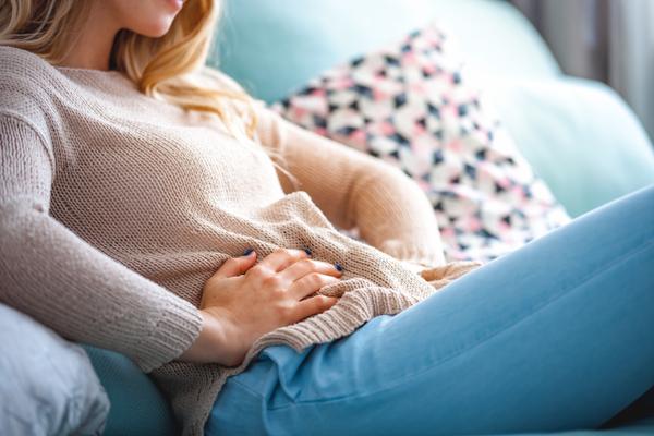 Frau hält die Hände auf dem Bauch