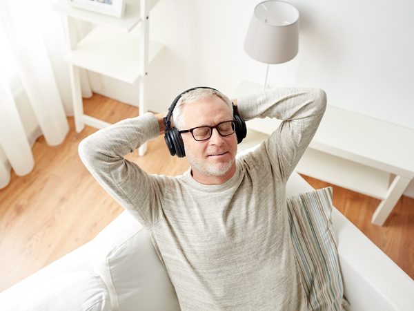 Zufriedener Mann genießt Entspannungsmusik.