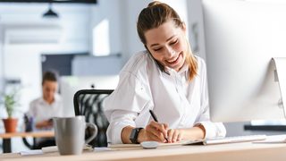 Lächelnde Frau telefoniert in der Kundenberatung