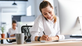 Lächelnde Frau telefoniert in der Kundenberatung - Für Traumeel
