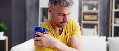 Mann kühlt sich die Schulter mit einem Kühlpad.