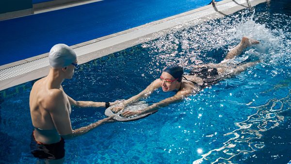Zwei Schwimmer im Becken mit Schwimmbrett – effektives Training mit Schwimmhilfe für Technik und Sicherheit