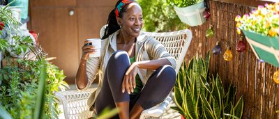 Frau im Sessel am Fenster – Entspannung und Linderung bei Zyklusstörungen durch natürliche Mittel.